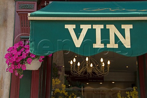 Detail of green awning over wine shop window in the   town square with spring flowers Beaune Cte dOr   France