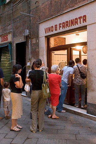 Queue outside wine and farinata shop in the old   quarter of Savona Liguria Italy