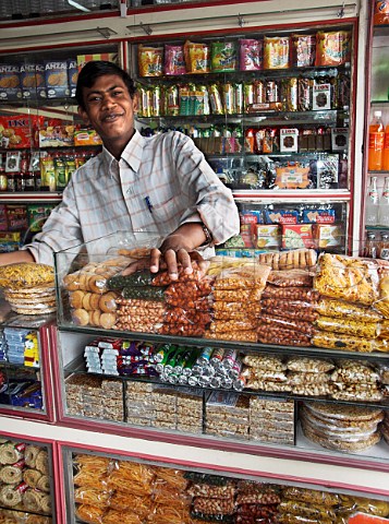 Indian man behind counter in general store Chennai   Madras India