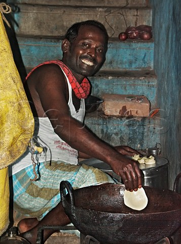Indian man cooking deepfried Indian bread Wadai   made from wheat flour or rice flour Chennai   Madras India