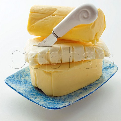A stack of butter pats with a knife