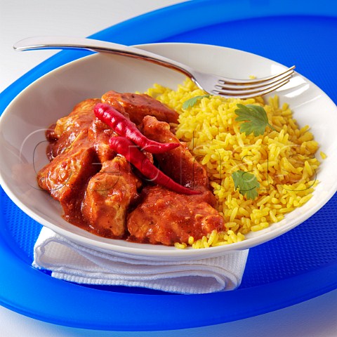 A plate of chicken rogan josh with saffron rice