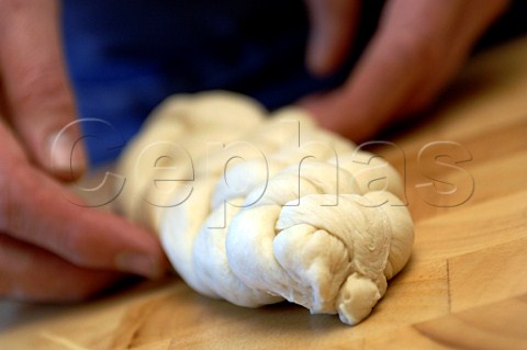 Baker holding a bread plait ready for baking