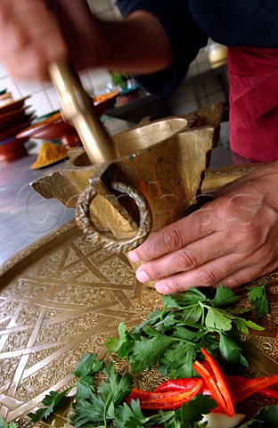 Grinding herbs and spices in a brass pestle and mortar