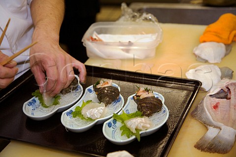 Preparing dab sashimi with sazaye shellfish in a Japanese restaurant