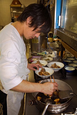 Preparing daikon radish and fish starter in a Japanese restaurant kitchen