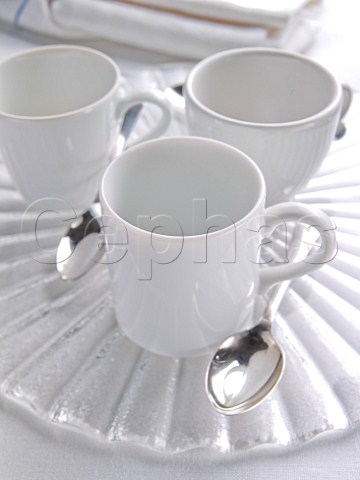 Three white coffee mugs with spoons