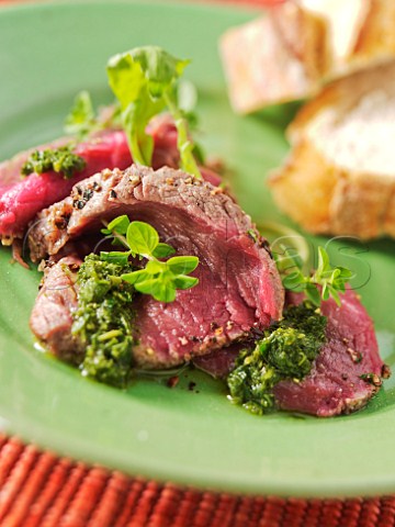 Rare beef slices with Salmoriglio dressing and crusty bread Olive oil lemon and herb warm dressing
