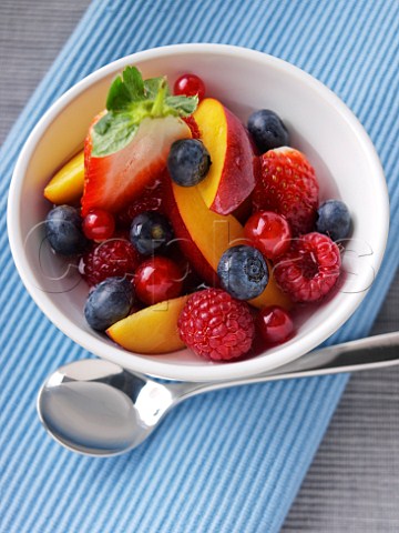 Fruit salad in a bowl with a spoon