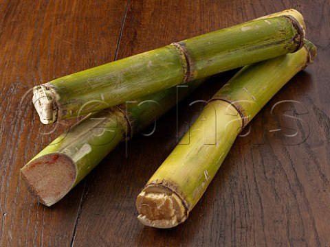Sticks of sugarcane on a dark wood background