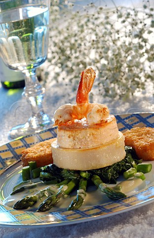 Seafood terrine with butterfly prawn on a bed of asparagus spears