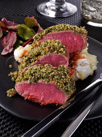 Plate of lamb loin in a herb crust with mash
