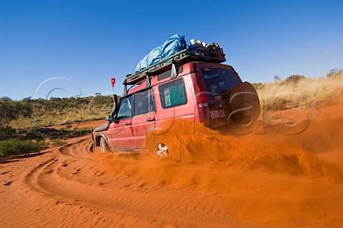 4WD car crossing sand dune on the Canning Stock Route Western Australia