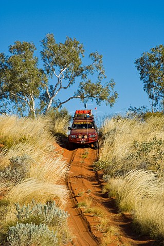 4WD car crossing sand dune on the Canning Stock Route Western Australia