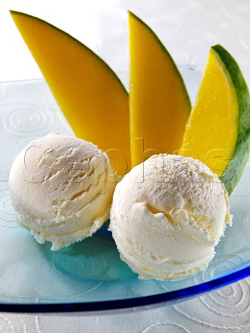 Two scoops of mango icecream with mango slices