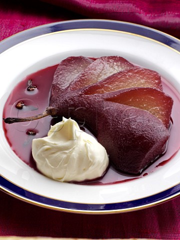Plate of poached pears in red wine with crme frache