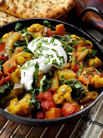 Vegetable Balti curry with naan bread and yoghurt topping