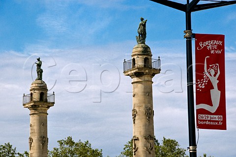 Pillars at the entrance of Place des Quinconces with wine festival banner Bordeaux Gironde France