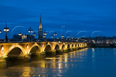 The spire of the church of StMichel church and Pont de Pierre reflecting in the Garonne River Bordeaux Gironde France