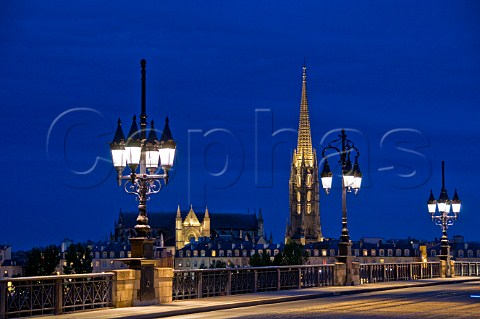 The spire of the church of StMichel and lights of Pont de Pierre at night Bordeaux Gironde France