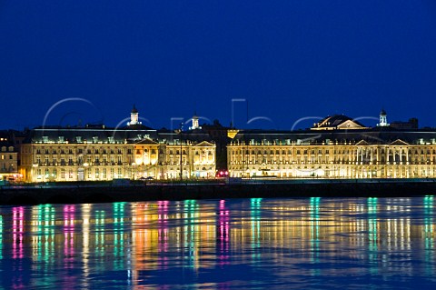 Street lights on the riverside promenade at Place de la Bourse reflecting in the Garonne river at night Bordeaux Gironde France
