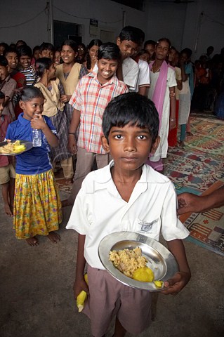 Young Indian boy with plate of food at the Compassion Ayanavaram Child Development Centre in the India Pentecostal Church of God IPC Thiruvalluvar Nagar Ayanavaram Chennai Madras India