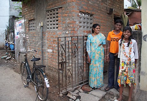 Indian family outside their brick house Thiruvalluvar Nagar Ayanavaram Chennai Madras India