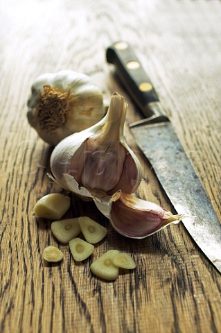 Garlic bulbs and slices on wood