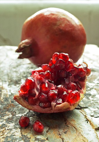 Pomegranate and seeds on stone