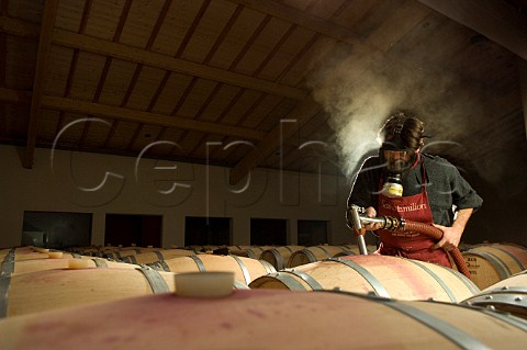 Filling barriques with new wine in the cellar of Chteau Mazeyres The mask is worn for protection against the fumes of sulphur which has been used to sterilise the barriques Pomerol Gironde France Pomerol  Bordeaux