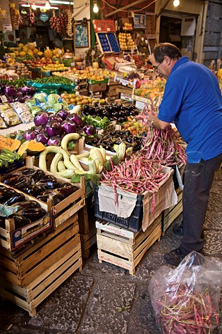 Man setting out a fruit and vegetable stall at the Vucceria Palermo Sicily