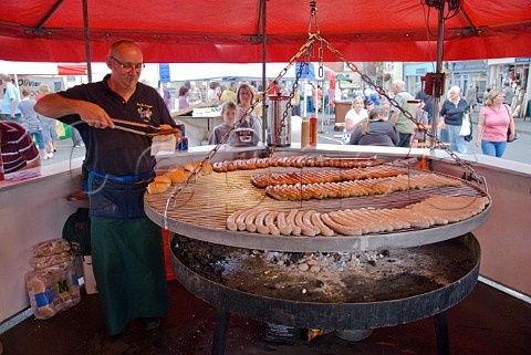 Cooking Dutch sausages at a continental market in Malton North Yorkshire England