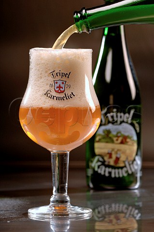 Pouring glass of Tripel Karmeliet Belgian beer