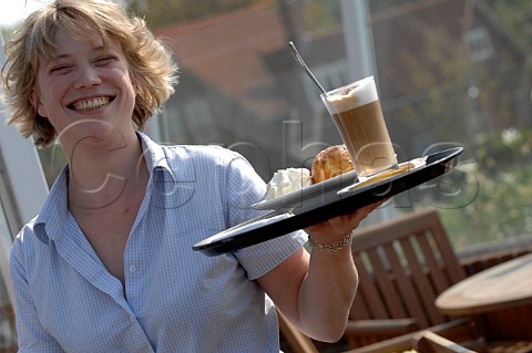 Waitress serving hot drinking chocolate and cream dessert