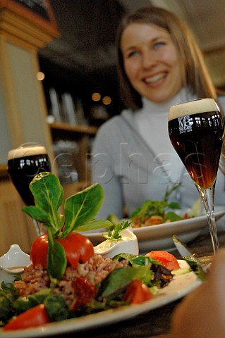 Couple eating salad with glasses of Belgian beer