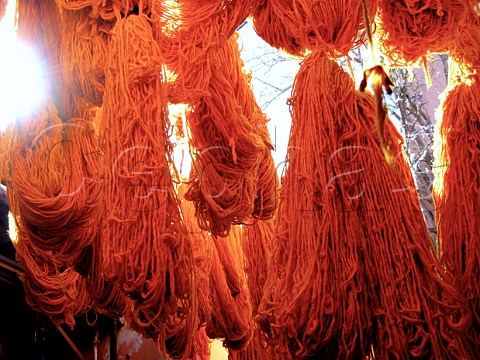Hanks of orange wool on sale in the souk  Marrakech Morocco