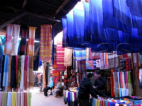 Brightly coloured cloth on sale in the souk Marrakech Morocco