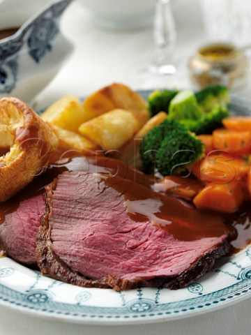 Slices of topside roast beef dinner in a table setting