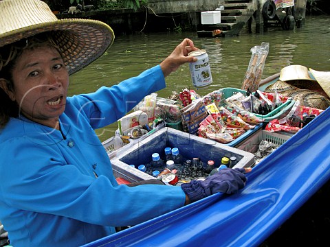 Woman selling beer drinks and snacks from her boat on the Chao Phraya river Bangkok Thailand