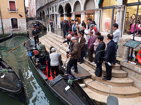 Group of tourists boarding a gondola at Bacino Orseolo San Marco Venice Italy