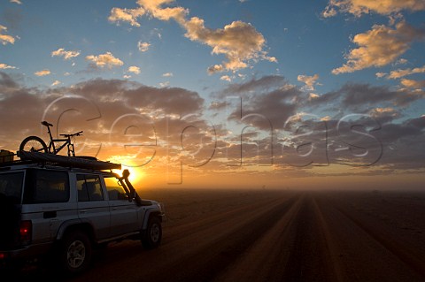 4WD vehicle on foggy road at sunrise near Wanaaring New South Wales Australia