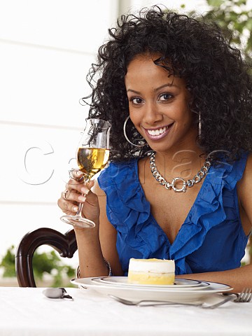Young woman drinking glass of ice wine in restaurant