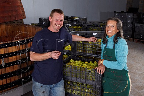 Pip Goring owner with winemaker Dermot Sugrue and harvested Chardonnay grapes by their Coquard press in the winery of Wiston Estate near Worthing Sussex England