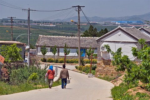 Couple walking towards Treaty Port winery Mulangou Village near Penglai Shandong Province China
