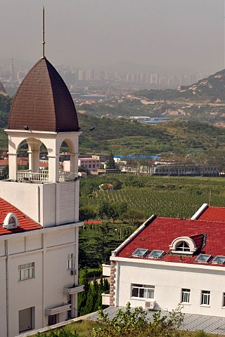 Chateau and vineyard at HuadongParry winery with Qingao city in the distance Laoshan District Qingdao Shandong Province China
