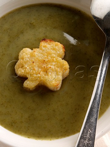 A bowl of sorrel soup with a shamrock shaped toast crouton