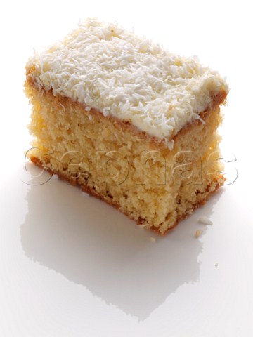A slice of coconut cake on a white background