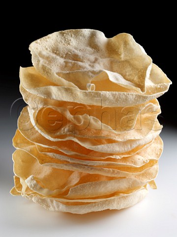 A pile of poppadoms on a white background
