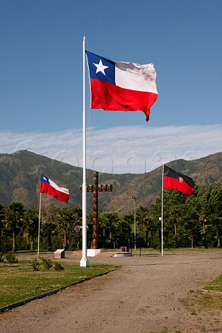 Flags of Chile and Santa Cruz next to a cross made of barrels in a park at Santa Cruz Colchagua Valley Chile