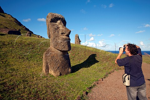 Tourist photographing a Moai on the slopes of Rano Raraku Easter Island